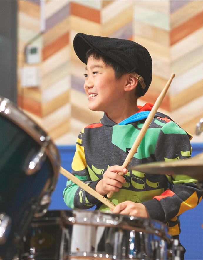 ドラムをたたく小学生の男の子