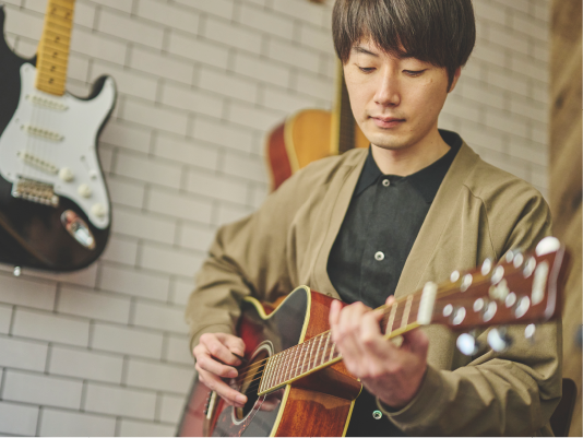 真剣な様子でギターを弾く講師