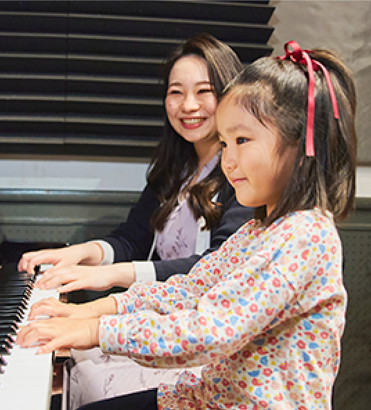 ピアノを弾く女の子と講師