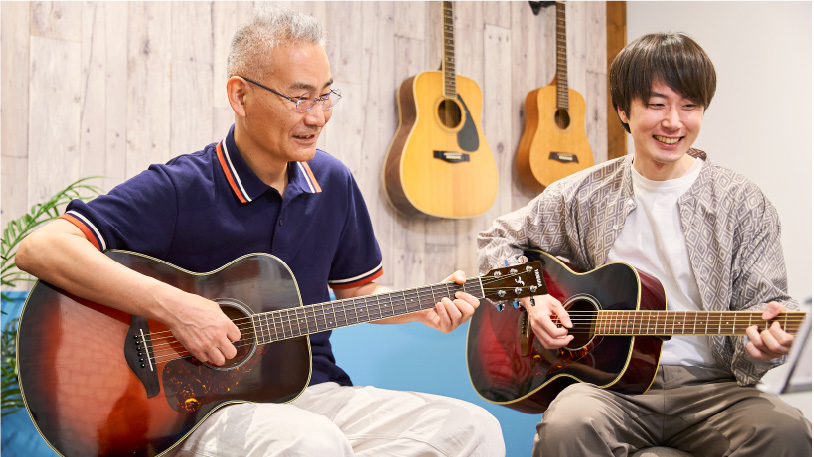 アコースティックギターを演奏している男性と講師