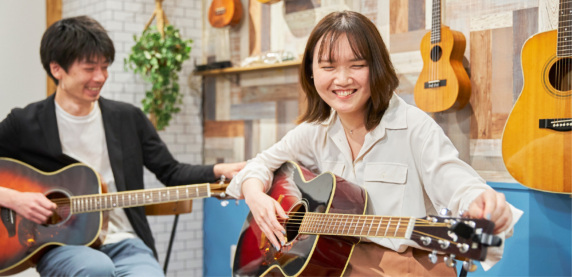 アコースティックギターをもつ女性と講師