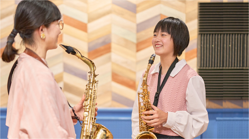 サックスを演奏している中学生と女性講師