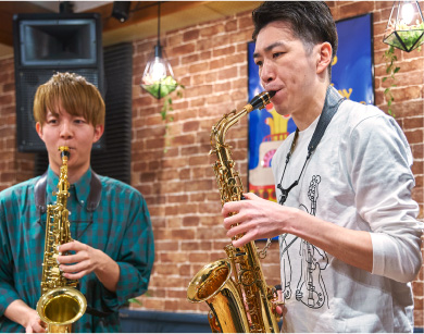 サックスを演奏している男性の生徒と講師